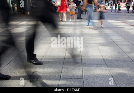 Berlin, Deutschland, verschwommene Schritte von zwei Männern in Anzügen vor Passanten Stockfoto