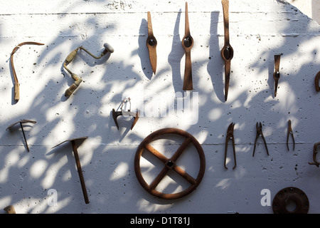 Alten, rostigen, landwirtschaftliche Werkzeuge, die an einer Wand hängen Stockfoto
