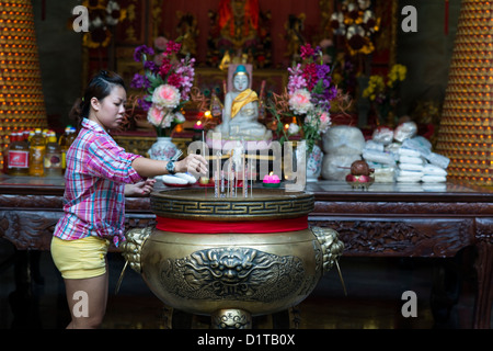 Ein buddhistische Anhänger legt Angebote von Weihrauch in einem Schrein in der chinesischen Thean Hou Tempel in Penang, Malaysia Stockfoto