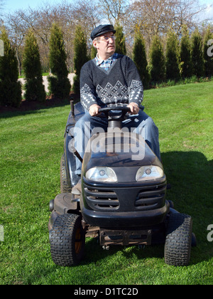 Ältere Mann sitzt auf schwarzen kleinen Gartentraktor und schneiden Rasen im Garten, Vorderansicht Stockfoto