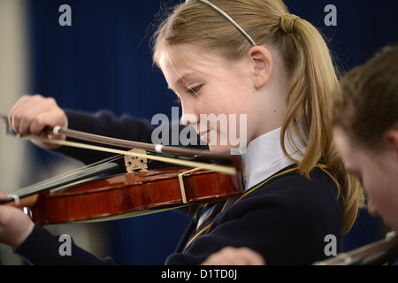 Ein Mädchen, Geige zu spielen, während eine Musikstunde Muttergottes & St. Werburgh der katholischen Grundschule in Newcastle-under-Lyme, Personal Stockfoto