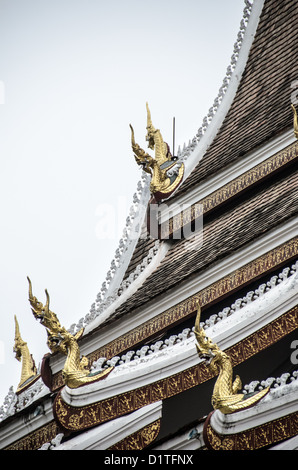 Buddhistischer Tempel Chofahs Dachdetail Luang Prabang Laos / LUANG PRABANG, Laos — goldene Chofahs zieren das Dach eines Wassers in Luang Prabang. Die hornartigen architektonischen Ornamente stellen Garuda dar, eine mythische Kreatur, die in hinduistischen und buddhistischen Traditionen halb Mensch und halb Vogel ist. Chofahs sind traditionelle dekorative Elemente, die auf Tempeldächern in ganz Südostasien zu finden sind und sowohl dekorativen als auch spirituellen Zwecken dienen. Luang Prabang, seit 1995 UNESCO-Weltkulturerbe, ist bekannt für seine gut erhaltene Sammlung buddhistischer Tempel und die traditionelle laotische Architektur. Der an Stockfoto