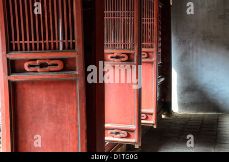 HANOI, Vietnam – dekorierte rote Holzfalttüren am Literaturtempel in Hanoi. Der Tempel wurde 1070 erbaut und ist einer von mehreren Tempeln in Vietnam, die Konfuzius, Weisen und Gelehrten gewidmet sind. Stockfoto