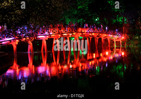 HANOI, Vietnam – die Huc-Brücke (Morgensonnenbrücke) bei Nacht. Die rot gestrichene Holzbrücke verbindet das Nordufer des Sees mit der Jade Island und dem Tempel des Jade Mountain (Ngoc Son Temple). Stockfoto