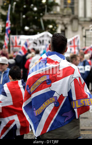 Belfast, UK. 5 Jan, 2013. Ein Mann Vorhänge ein Union Jack Flagge, die zeigt die sechs Grafschaften Nordirlands. Die Flagge Protest in Belfast statt, nachdem der Rat der Stadt am 3. Dezember 2012 stimmten die fliegenden der Union Jack Flagge vom Rathaus bis zu 17 Tage pro Jahr, wo früher flog es jeden Tag des Jahres zu beschränken. Stockfoto