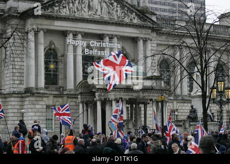 Belfast, UK. 5. Januar 2013. Glückliche Weihnachten Belfast Zeichen werden hinter einer großen Union Jack-Flagge gesehen, die während der laufenden Protest Flagge geschwenkt wurde. Der Flag-Protest fand in Belfast, nachdem der Stadtrat am 3. Dezember 2012 stimmte, das Fliegen zu beschränken, die, das die Union Jack, Flagge vom Rathaus bis 17 Tage pro Jahr, wo zuvor flog es jeden Tag des Jahres. Stockfoto