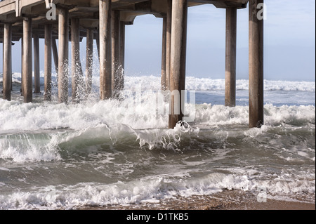 Ein harter Tag am Strand zeigt verwirrt Wasserbewegung um einen Pier. Stockfoto