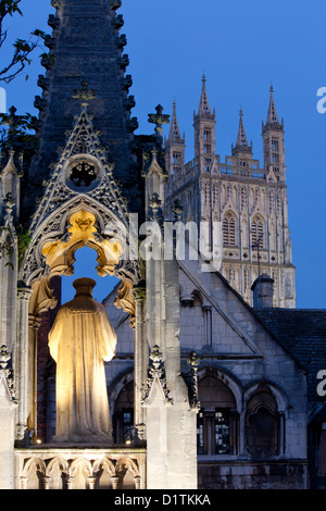 Kathedrale von Gloucester Mittelturm in der Dämmerung / Dämmerung / Nacht mit Statue im Vordergrund Gloucestershire England UK Stockfoto