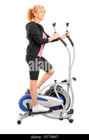 In voller Länge Portrait von einer reifen Frau Training auf einem Crosstrainer isoliert auf weißem Hintergrund Stockfoto