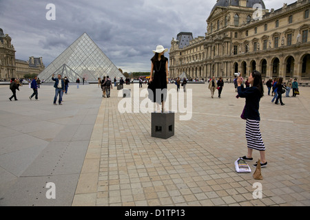 Eine junge Frau fotografiert ihre Freundin vor die Glaspyramide des Louvre, Paris, Ile De La Cite, Frankreich Stockfoto
