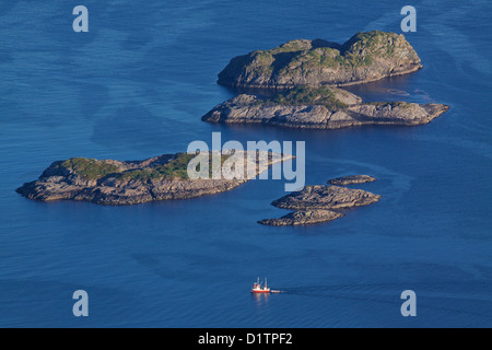 Vogelperspektive Fischerboot Segeln zwischen von felsigen Inselchen in der Nähe von Henningsvær auf Lofoten in Norwegen Stockfoto