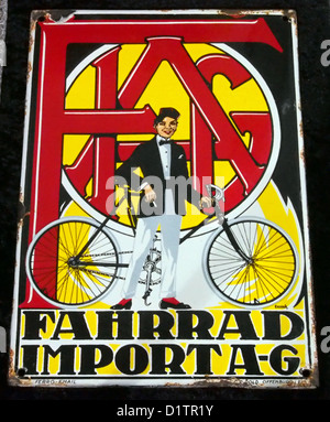 Ein emailliertes Werbezeichen für Fahrrad Import A-G, ein Unternehmen, das an der Einfuhr von Fahrrädern beteiligt ist. Dieses Vintage-Schild spiegelt die Marketingtechniken der Mitte des 20. Jahrhunderts wider und ist ein Sammlerstück aus der Ära der Fahrradwerbung. Das Schild zeigt unverwechselbare Farben und Designelemente der Zeit. Stockfoto