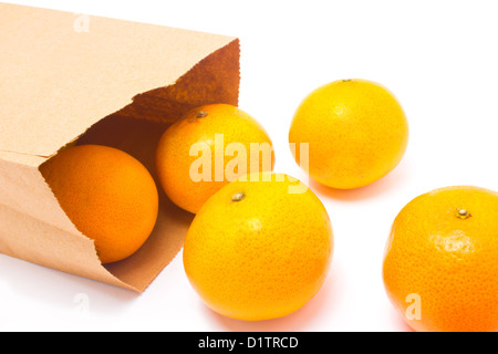 Orangen aus Papiertüte, isoliert auf weißem Hintergrund fallen. Stockfoto