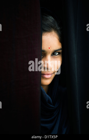 Indische Mädchen Lächeln durch dunkle Schals. Indien Stockfoto