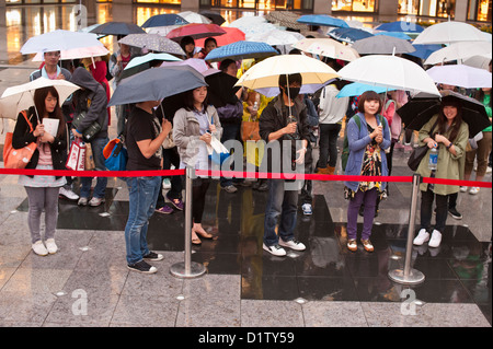 Menschenmenge wartete unter Sonnenschirmen, Taipei Stockfoto