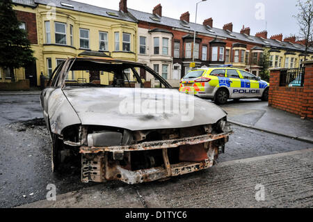 6. Januar 2013, Belfast, Nordirland - sitzt A PSN Polizeiauto neben einem ausgebrannten Auto, wie es auf der Albertbridge Straße in East Belfast nach einer durchzechten Nacht Ausschreitungen von mehr als 300 Menschen bleibt. Alamy Live-Nachrichten. Stockfoto