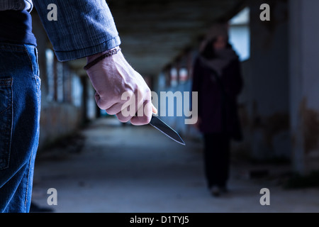Verbrecher mit Messer wartet eine Frau Stockfoto