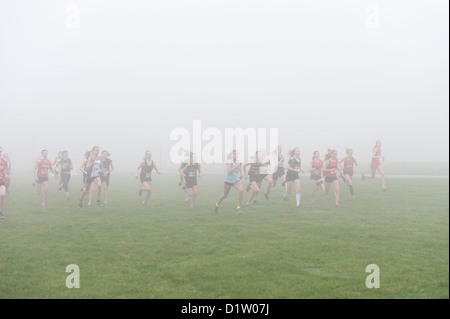 Kent Cross Country Meisterschaften unter 15 Mädchen Jugend läuft auf Trail-Pfad durch Wald im Nebel und nebligen Bedingungen ausgeführt Stockfoto