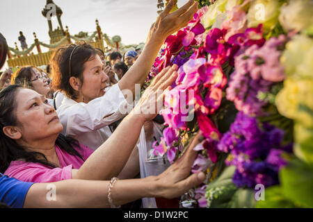 6. Januar 2013 - Bangkok, Thailand - Frauen schreien und versuchen, eine Reliquie zu erreichen, die ein Stück Haar des Buddha ist wie der LKW tragen die Reliquie einen besonderen Service für sie in Bangkok Sonntag verlässt. Die Reliquie wurde auf dem Display in Bangkok seit etwa 10 Jahren. Es war eine Zeremonie in Sanam Luang in Bangkok Sonntag, die Reliquie zu Ehren. Menschen für ihn beteten und Segnungen von buddhistischen Mönchen und Brahmanen-Priester, die den Vorsitz über den Dienst erhalten. Das Haar ist nach Ayutthaya, verschoben wird, wo es in einem buddhistischen Tempel angezeigt werden soll. Das Stück des Haares wurde auf Leihbasis zu Thai-Buddhisten Buddhist Stockfoto