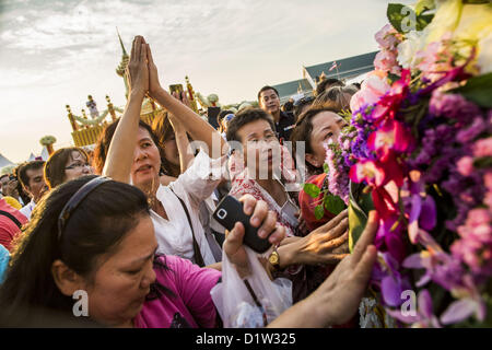 6. Januar 2013 - Bangkok, Thailand - Frauen schreien und versuchen, eine Reliquie zu erreichen, die ein Stück Haar des Buddha ist wie der LKW tragen die Reliquie einen besonderen Service für sie in Bangkok Sonntag verlässt. Die Reliquie wurde auf dem Display in Bangkok seit etwa 10 Jahren. Es war eine Zeremonie in Sanam Luang in Bangkok Sonntag, die Reliquie zu Ehren. Menschen für ihn beteten und Segnungen von buddhistischen Mönchen und Brahmanen-Priester, die den Vorsitz über den Dienst erhalten. Das Haar ist nach Ayutthaya, verschoben wird, wo es in einem buddhistischen Tempel angezeigt werden soll. Das Stück des Haares wurde auf Leihbasis zu Thai-Buddhisten Buddhist Stockfoto