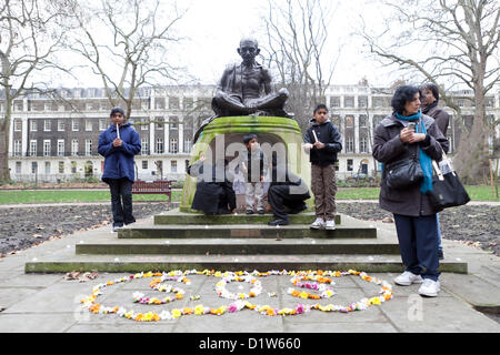 London, Samstag, 5. Januar 2013. Kerze Beleuchtung Memorial an Mahatma Gandhi Statue, Tavistsock Square Garden in London-Save unserer Schwestern. Demonstranten versammelten sich am Tavistock Garden Square zu protestieren und zeigen ihre Solidarität gegen den Vorfall, der in der indischen Hauptstadt Delhi stattfand, wo eine Frau Bande vergewaltigt und aus dem beweglichen Bus geworfen zu sterben war. NRI-Indianer In London wollen eine Antwort von der indischen Regierung für das Geschehene. Kinder gesehen, die Beleuchtung und halten brennende Kerzen in der Hand vor der Statue von Mahatma Gandhi. Stockfoto