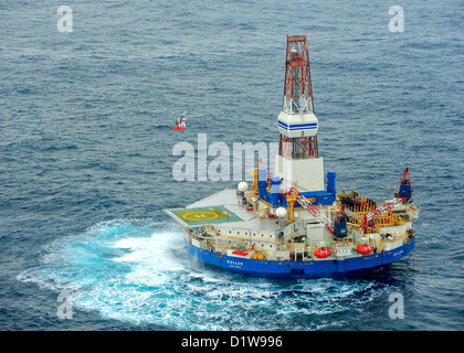 Ein Coast Guard MH-60 Jayhawk Helikopter hebt der ersten sechs der 18 Besatzungsmitglieder aus der mobile Bohreinheit Kulluk 29. Dezember 2012, 80 Meilen südwestlich der Stadt Kodiak, Alaska. Die Kulluk schwebte frei, nachdem das Schiff schleppen es macht und seine Schlepptau Verbindung des Kodiak-Archipels verloren. Stockfoto