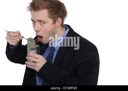 Mann isst Hundefutter in einer Blechdose Stockfoto
