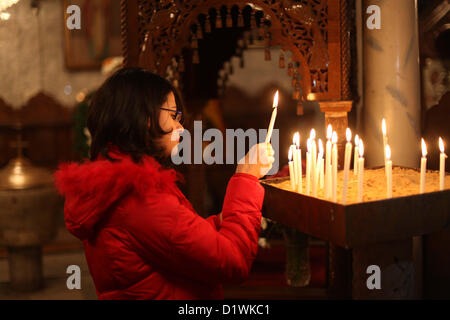 7. Januar 2013 - Gaza-Stadt, Gazastreifen, Palästinensische Gebiete - zündet palästinensischen orthodoxen christlichen Mädchen eine Kerze in der Kirche während der Weihnachtsfeier am 7. Januar 2013 in Gaza-Stadt. Orthodoxe Weihnachten fällt nach dem gregorianischen Kalender 13 Tage nach das 25 Dezember westlichen fest im Einklang mit dem Julianischen Kalender gefeiert (Credit-Bild: © Ashraf Amra/APA Images/ZUMAPRESS.com) Stockfoto