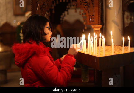 7. Januar 2013 - Gaza-Stadt, Gazastreifen, Palästinensische Gebiete - zündet palästinensischen orthodoxen christlichen Mädchen eine Kerze in der Kirche während der Weihnachtsfeier am 7. Januar 2013 in Gaza-Stadt. Orthodoxe Weihnachten fällt nach dem gregorianischen Kalender 13 Tage nach das 25 Dezember westlichen fest im Einklang mit dem Julianischen Kalender gefeiert (Credit-Bild: © Ashraf Amra/APA Images/ZUMAPRESS.com) Stockfoto