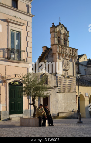 Alte Männer sprechen auf Hauptplatz in Matera, Stadt, Region Basilikata, Süditalien. Chiesa Materdomini und Spirito Santo Sassi. Stockfoto