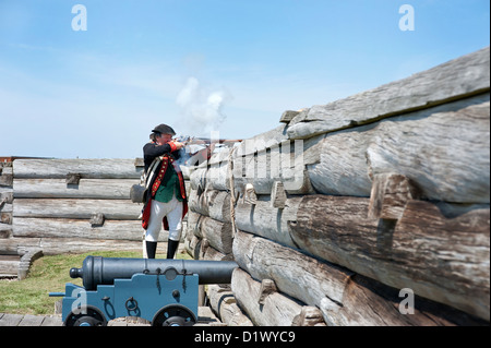 Fort Stanwix Reenactors: American Continental Artillery Soldaten feuern Muskete hinter Kastellmauern. Stockfoto