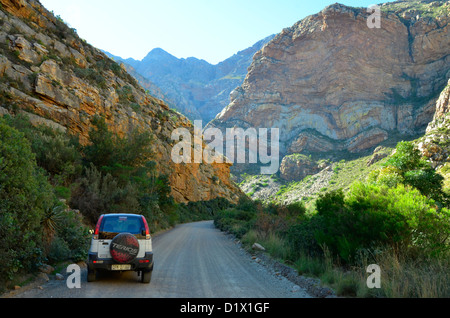 4 x 4 Fahrzeug in schmale, unbefestigte Straße schlängelt sich durch felsige Schlucht und verdrehten geschichteten Berg in Great Karoo, Südafrika Stockfoto