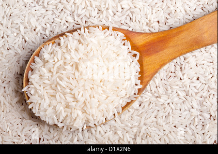 Reis-Hintergrund mit einem Holzlöffel. Stockfoto