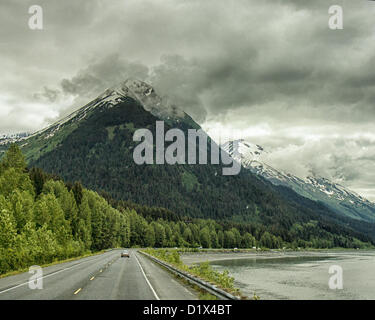 29. Juni 2012 - Halbinsel Kenai, Alaska, USA - nähert sich einer imposanten schneebedeckten Bergkette fahren Süden an malerischen Seward Highway im Chugach National Forest. Bezeichnet einen National Forest Scenic Byway, ein All-American Road und eine Alaska Scenic Byway, läuft Seward Highway 127 Meilen [204 km] von Anchorage, Seward, Kenai-Halbinsel, Chugach State Park und Chugach National Forest, ein Schaufenster für natürliche Schönheit und Vielfalt der Landschaften in Süd-Zentral-Alaska. (Kredit-Bild: © Arnold Drapkin/ZUMAPRESS.com) Stockfoto