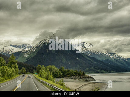 29. Juni 2012 - Halbinsel Kenai, Alaska, USA - nähert sich einer imposanten schneebedeckten Bergkette fahren Süden an malerischen Seward Highway im Chugach National Forest. Bezeichnet einen National Forest Scenic Byway, ein All-American Road und eine Alaska Scenic Byway, läuft Seward Highway 127 Meilen [204 km] von Anchorage, Seward, Kenai-Halbinsel, Chugach State Park und Chugach National Forest, ein Schaufenster für natürliche Schönheit und Vielfalt der Landschaften in Süd-Zentral-Alaska. (Kredit-Bild: © Arnold Drapkin/ZUMAPRESS.com) Stockfoto