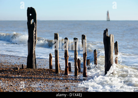 Wellen brechen gegen Wasser getragen Hölzer des Küstenschutzes am Strand. Rye Harbour, Sussex, UK Stockfoto