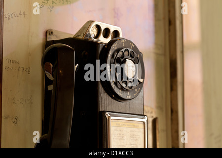 Vintage Wählscheibe Münztelefon auf Wand Stockfoto