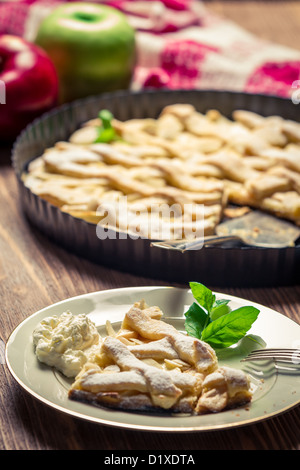 Nahaufnahme von Stück Apfelkuchen mit Sahne auf einem Teller Stockfoto