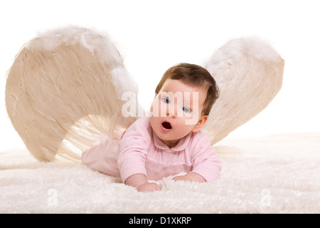 Baby Mädchen Engel mit Feder weißen Flügeln auf weißem Fell Stockfoto