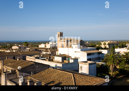 Calonge, Mallorca, Balearen, Spanien. Blick über die Dächer bis zur Dorfkirche. Stockfoto