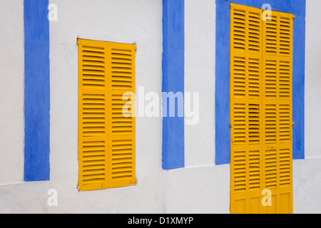 Portocolom, Mallorca, Balearen, Spanien. Fassade des blauen und weißen Haus mit gelben Fensterläden in der Altstadt. Stockfoto