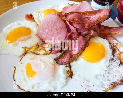 Vier Spiegeleier mit gebratenem Speck auf einem Teller Stockfoto