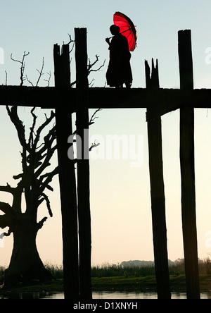 Buddhistischer Mönch U Bein Brücke bei Sonnenuntergang, Amarapura, in der Nähe von Mandalay, Birma (Myanmar), Südost-Asien. Stockfoto