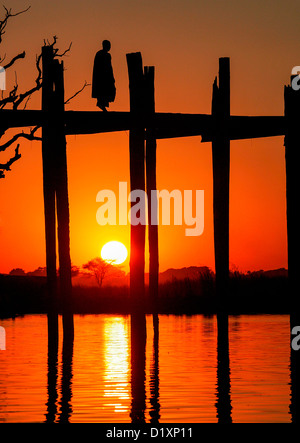 Buddhistischer Mönch U Bein Brücke bei Sonnenuntergang, Amarapura, in der Nähe von Mandalay, Birma (Myanmar), Südost-Asien. Stockfoto