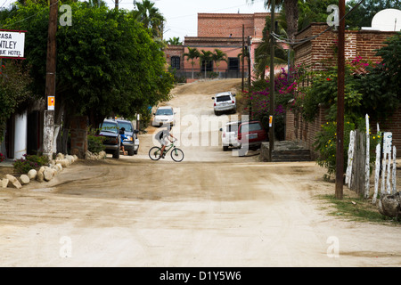 Ein kleiner Junge fährt Fahrrad auf einer unbefestigten Straße in Todos Santos, Baja, Mexiko Stockfoto