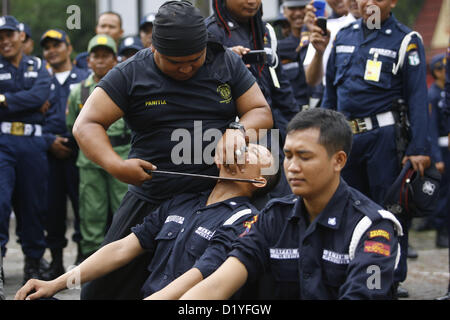 9. Januar 2013 - Solo, Java, Indonesien - 9. Januar 2013 - Solo, Java, Indonesien - ein Wachmann zeigt die Macht immun zu schneiden seine Kehle mit einer Machete während einer Zeremonie anlässlich des 32. Jahrestages der zivilen Sicherheitskräfte Organisation am 9. Januar 2013 in Solo, Zentraljava, Indonesien sein. Indonesiens Wachleute werden von privaten Unternehmen zur Sicherheitsleistung für Organisationen wie Banken, Büros, Schulen und andere. (Bild Kredit: Kredit: Sijori Images/ZUMAPRESS.com/Alamy Live-Nachrichten) Stockfoto