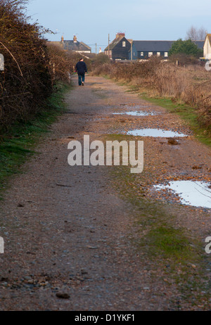 Kies nass Schotterweg mit Pfützen nach Regen Stockfoto