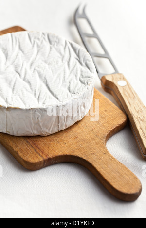 Camembert Käse mit Messer am Küchentisch Stockfoto