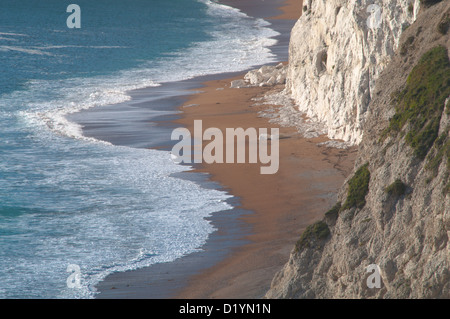 Der Strand und brechen Surfen unterhalb der Kreidefelsen kratzig unten, Durdle Door, Dorset, England, UK. Stockfoto