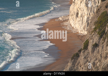 Der Strand und brechen Surfen unterhalb der Kreidefelsen kratzig unten, Durdle Door, Dorset, England, UK. Stockfoto